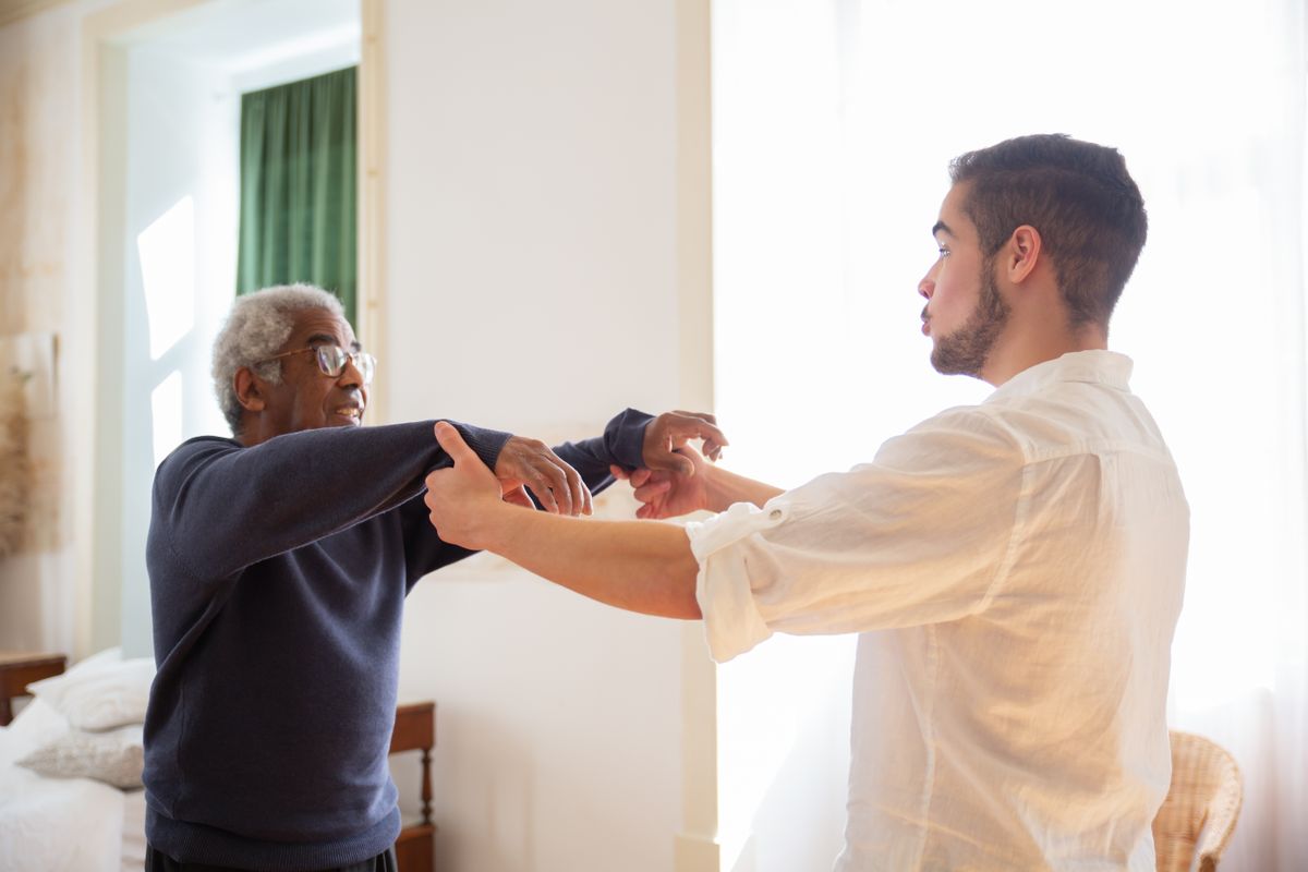 Caregiver assisting an elderly resident with gentle support at home